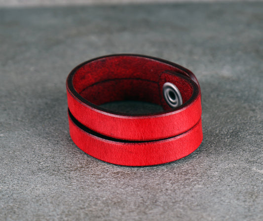 Red leather bracelet on a gray surface