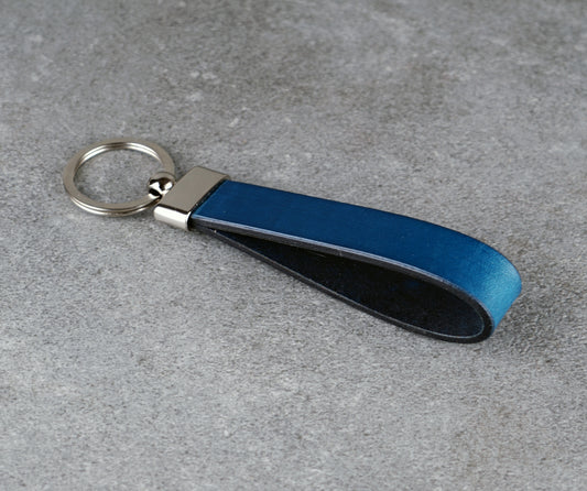 Blue leather keychain on a gray surface