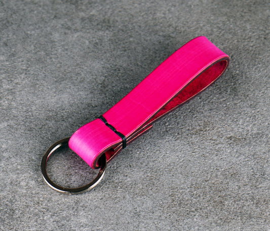 Pink keychain strap on a gray textured background