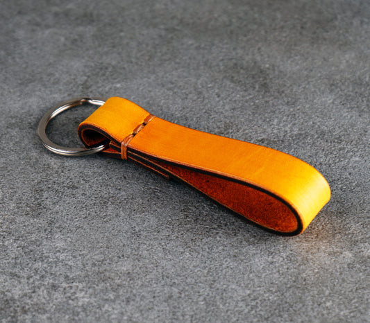 yellow leather keychain on a gray surface