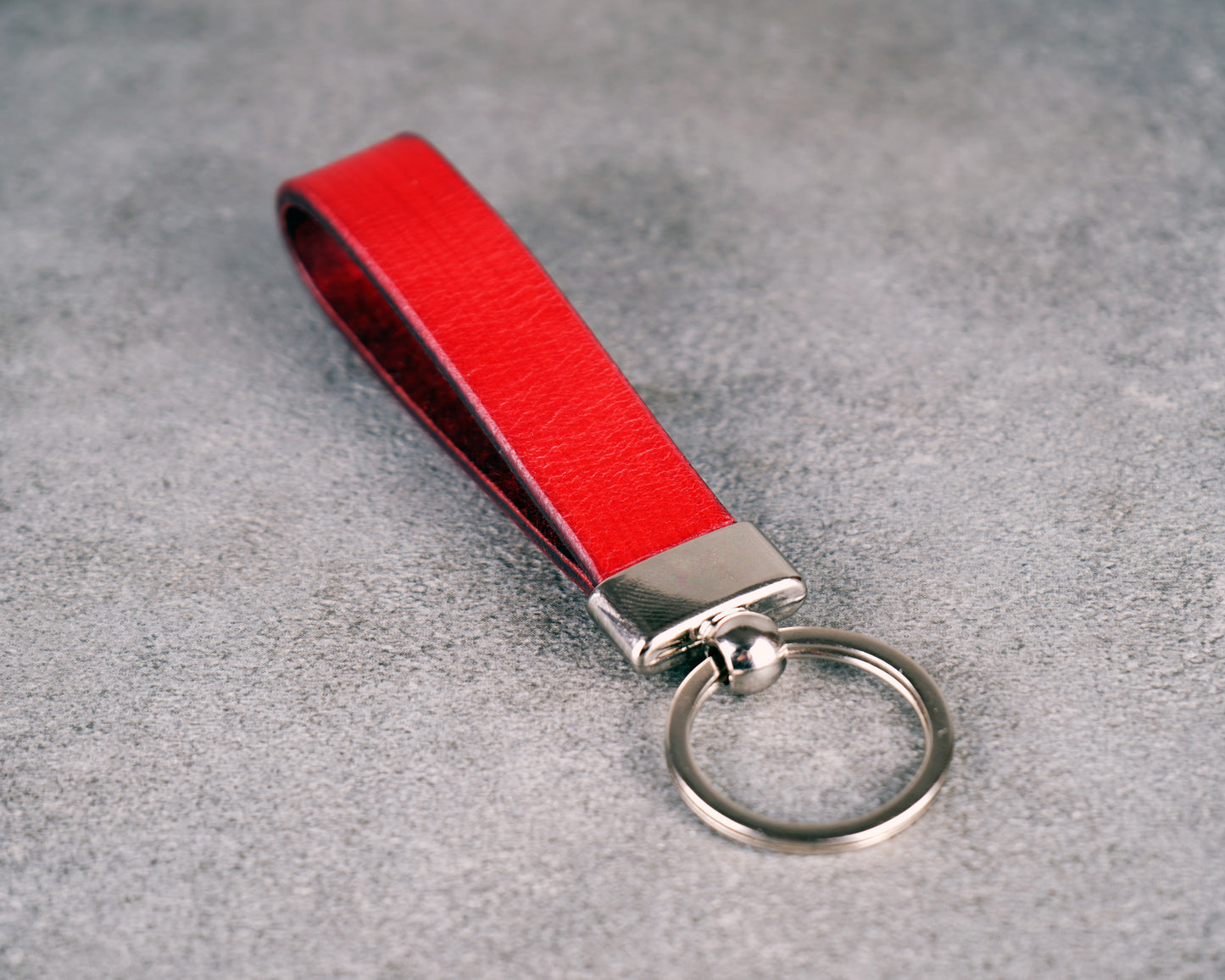 Red keychain with a metal ring on a gray surface