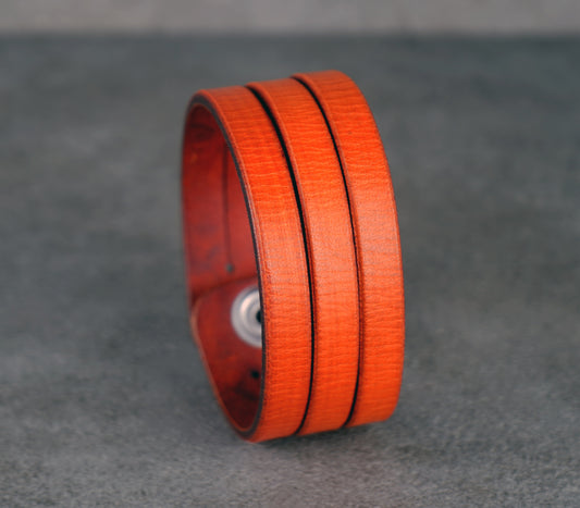 Orange leather bracelet on a gray background