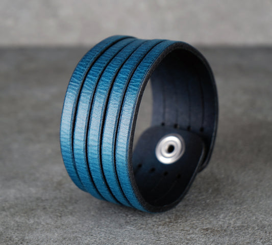 Blue leather bracelet on a gray surface