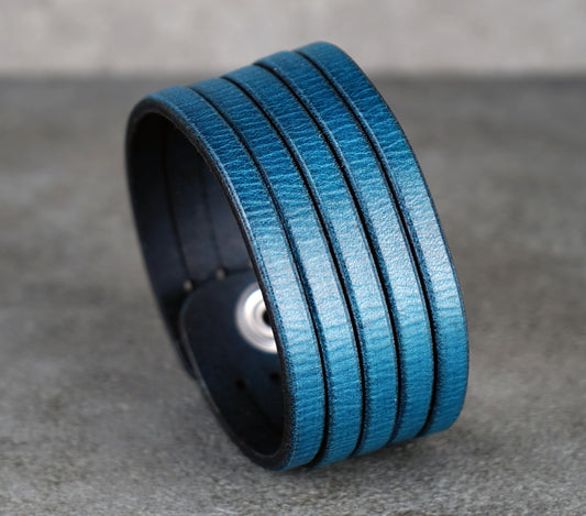 Blue leather bracelet on a gray surface