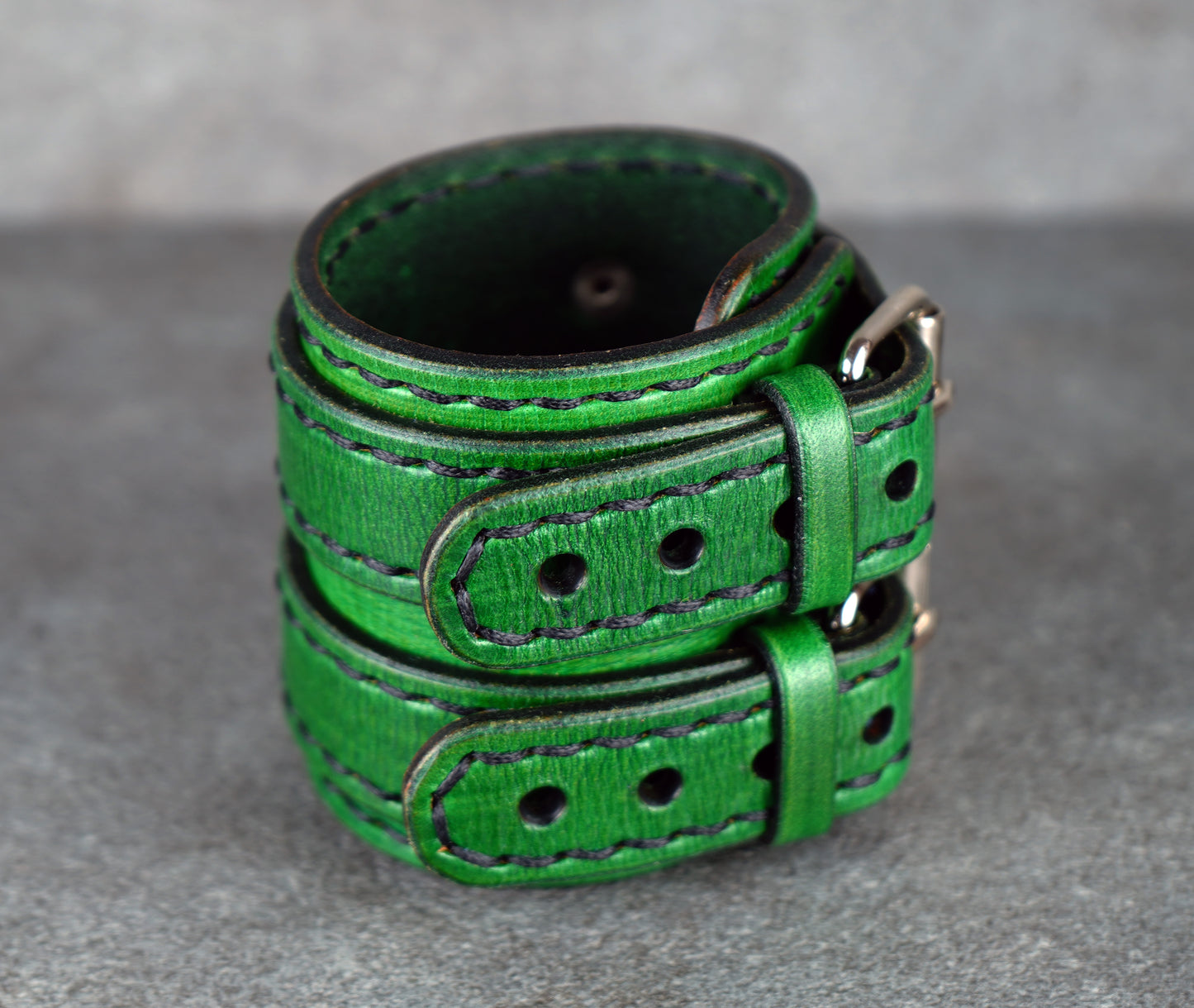 Green leather belt on a gray surface