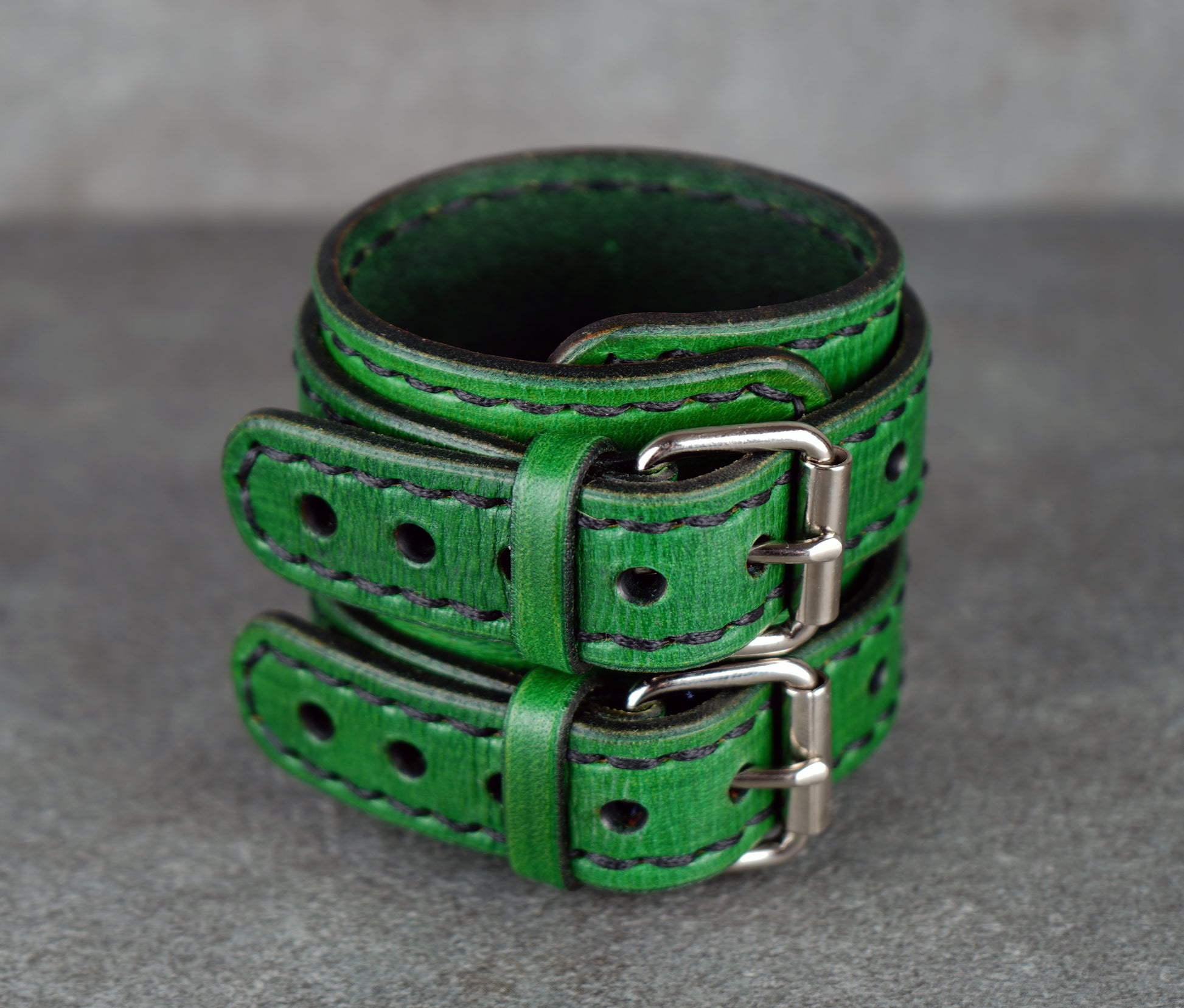 Green leather belt on a gray surface