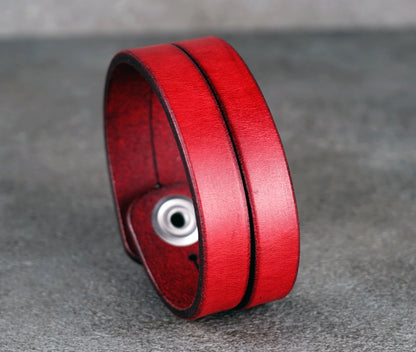 Red leather bracelet on a gray surface