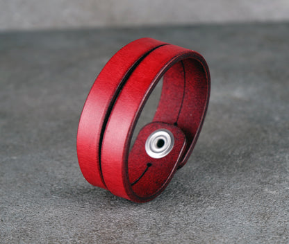 Red leather bracelet on a gray surface