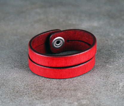 Red leather bracelet on a gray surface