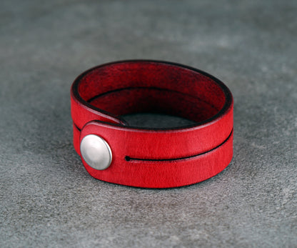 Red leather bracelet on a gray surface