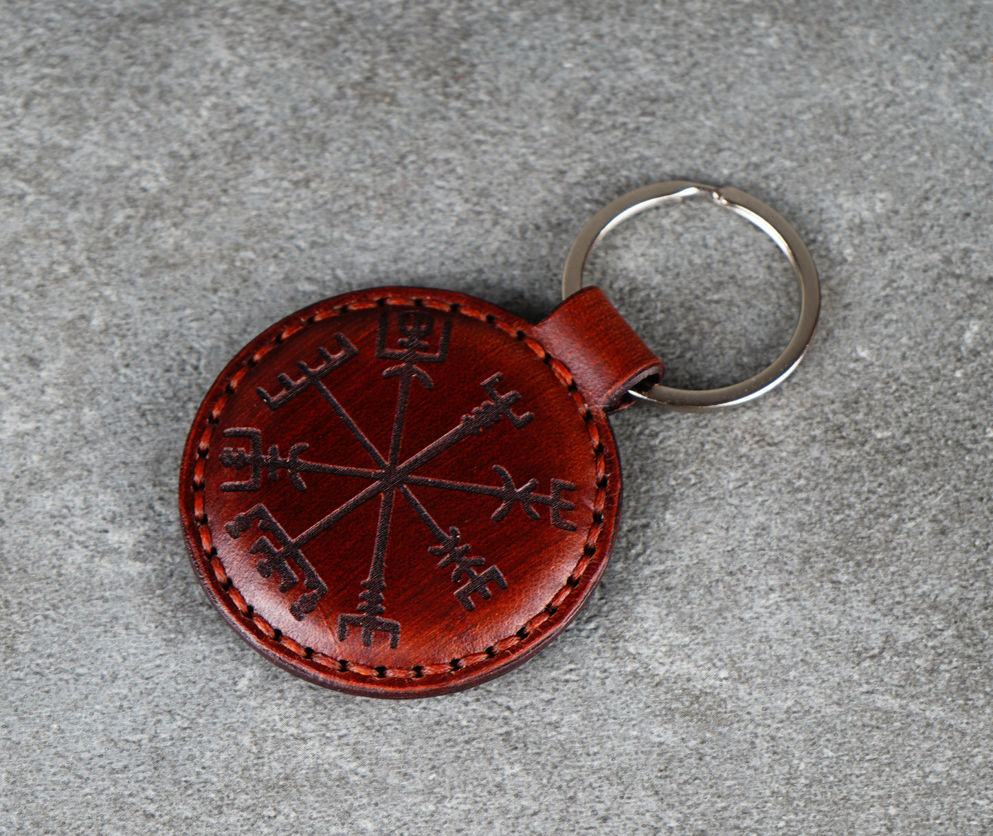 Brown leather keychain with a star design on a gray surface