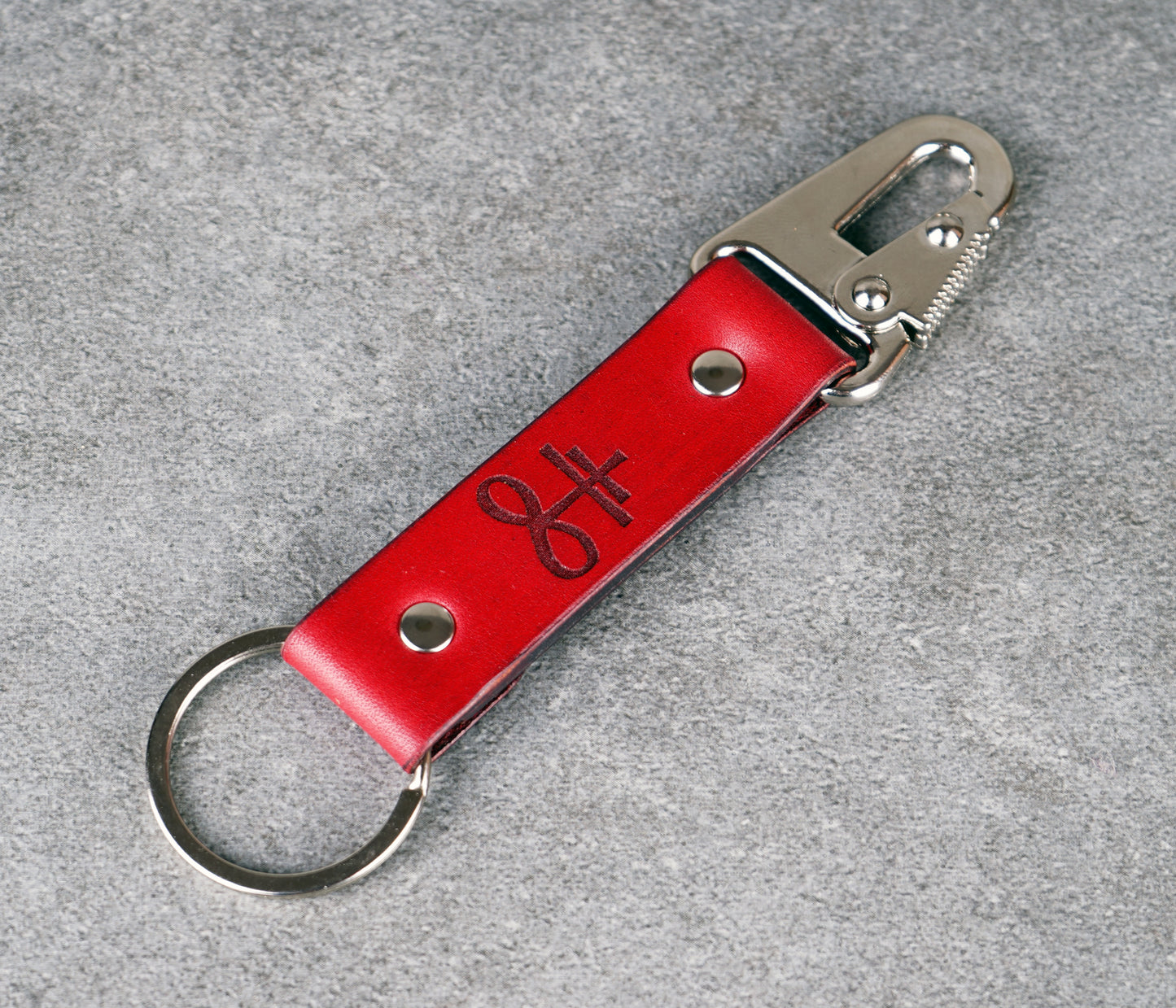 Red leather keychain with metal clip on a gray background