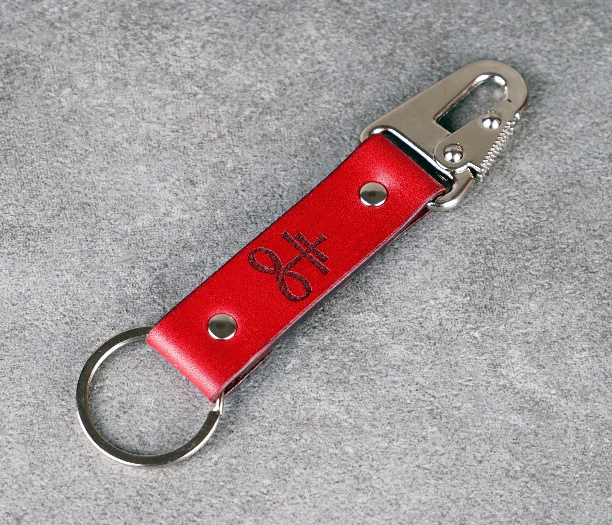 Red leather keychain with metal clip on a gray background