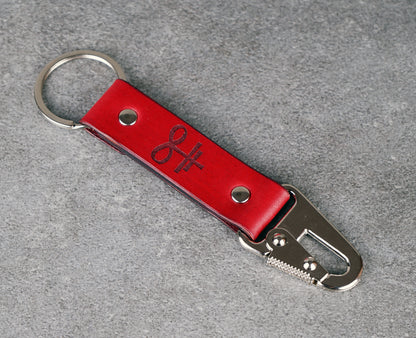 Red leather keychain with metal clip on a gray background