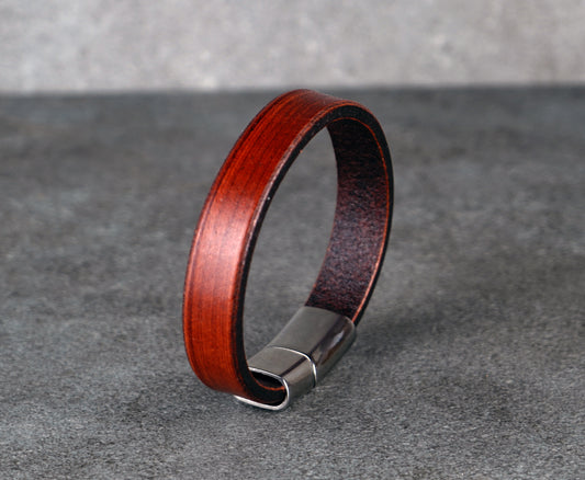 Wooden bracelet with metal clasp on a gray background