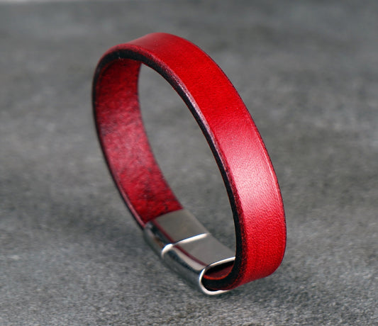 Red leather bracelet on a gray textured surface