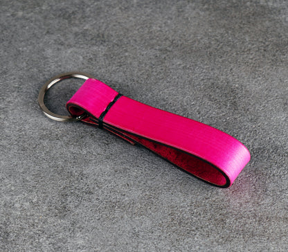 Pink keychain with a metal ring on a gray surface