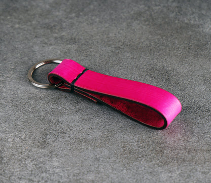 Pink leather keychain on a gray surface