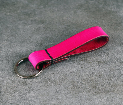 Pink keychain with a metal ring on a gray surface