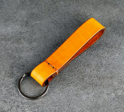 yellow leather keychain on a gray surface