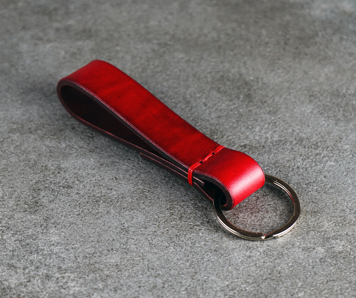 Red leather key fob on a gray surface