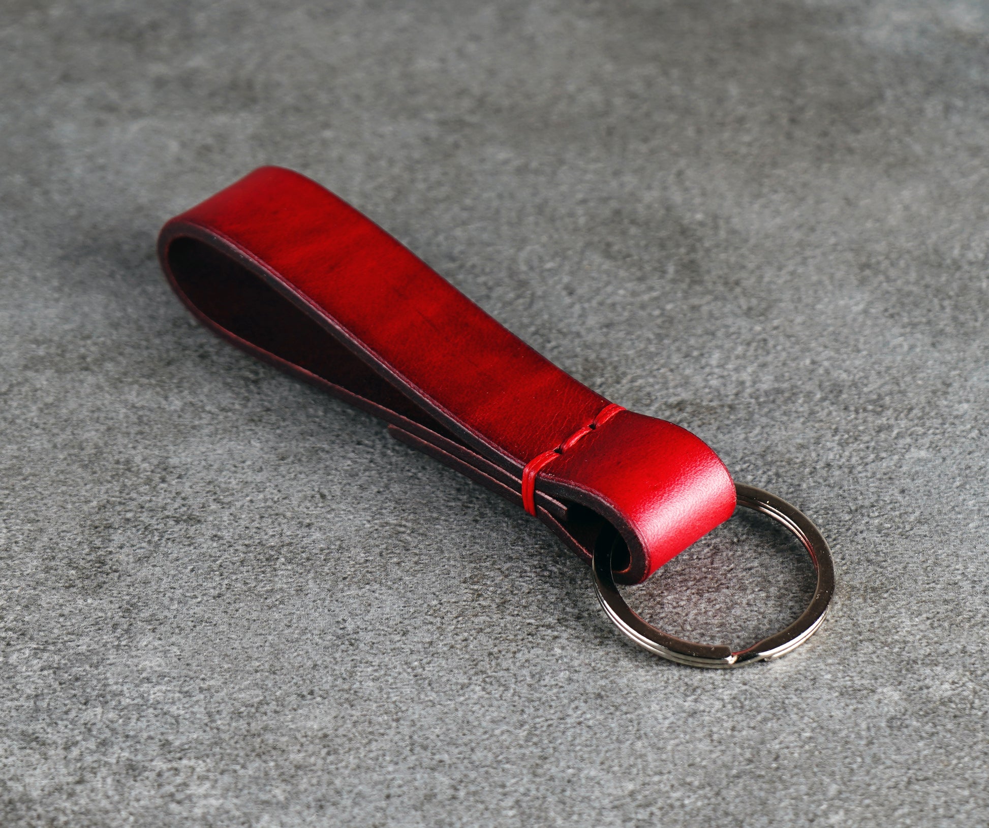Red leather key fob on a gray surface