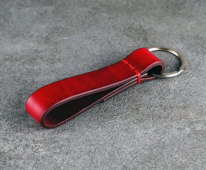 Red leather keychain on a gray surface
