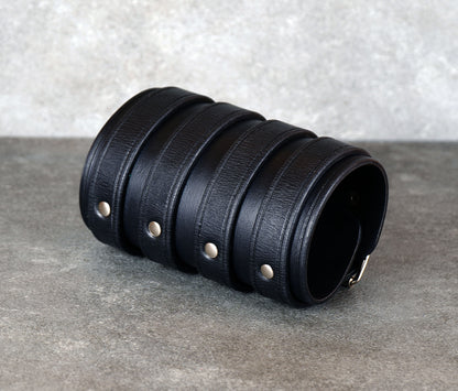 Wide black leather cuff bracelet handmade from vegetable-tanned leather with minimalist design