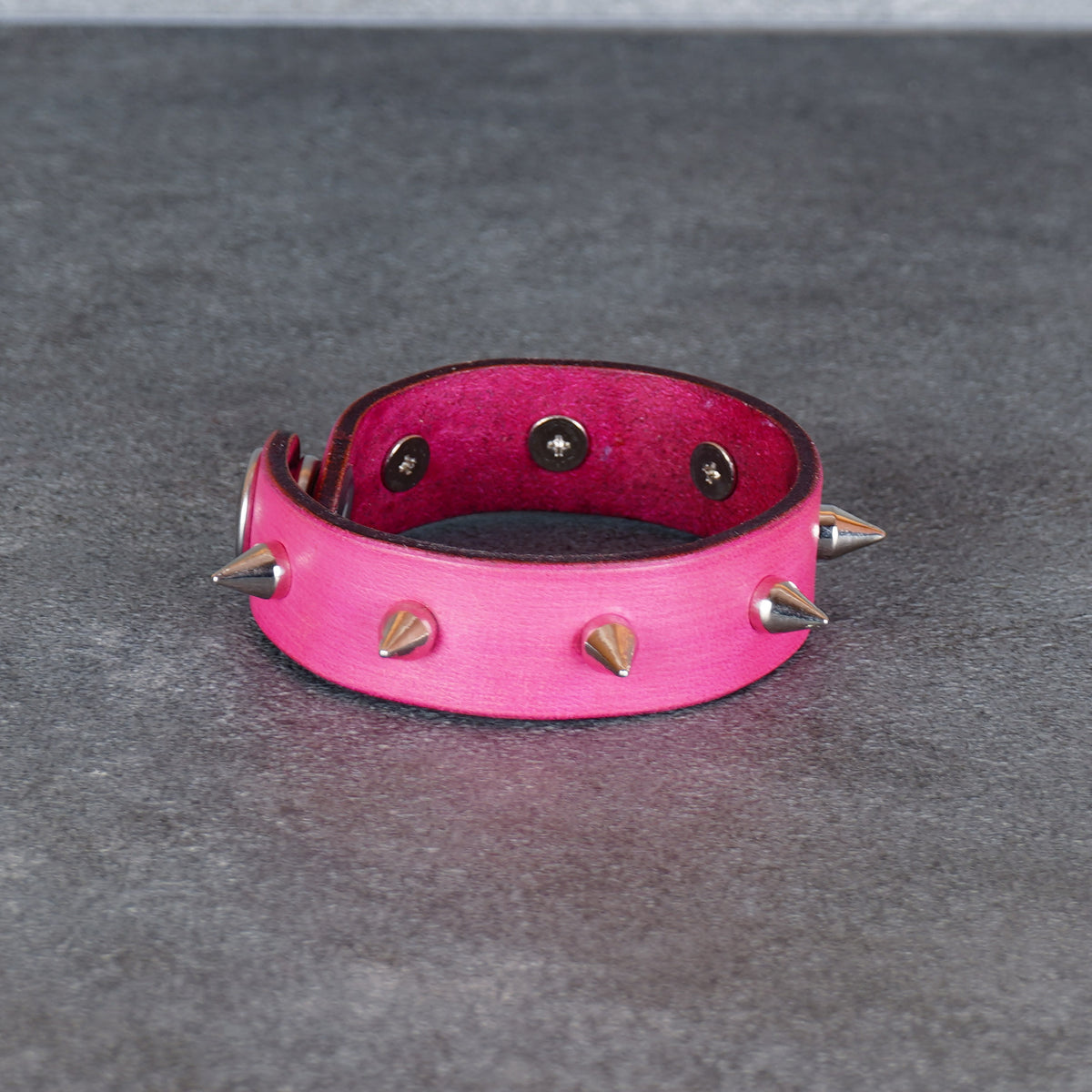 Spiked pink leather bracelet shown flat with the cuff open