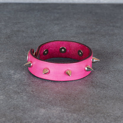 Spiked pink leather bracelet shown flat with the cuff open