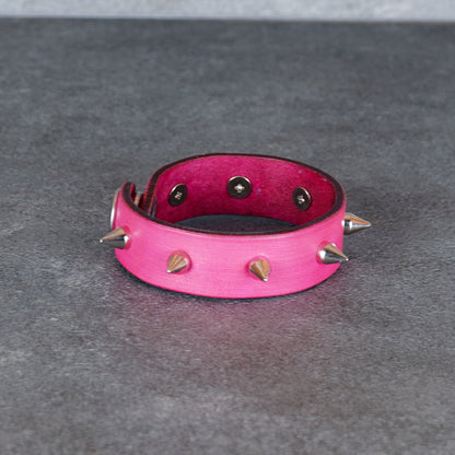 Spiked pink leather bracelet shown from a front-facing studio view