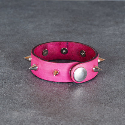 Pink spiked bracelet with a visible snap stud on the side