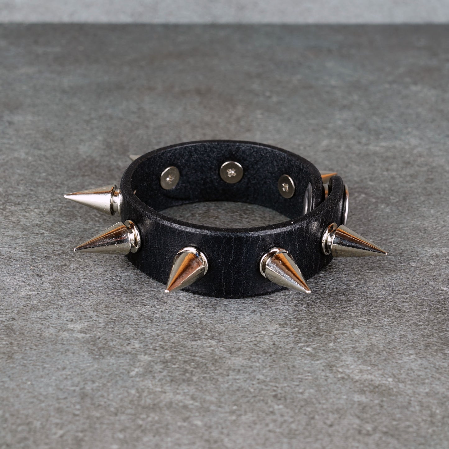 Black leather bracelet styled for punk rock outfits