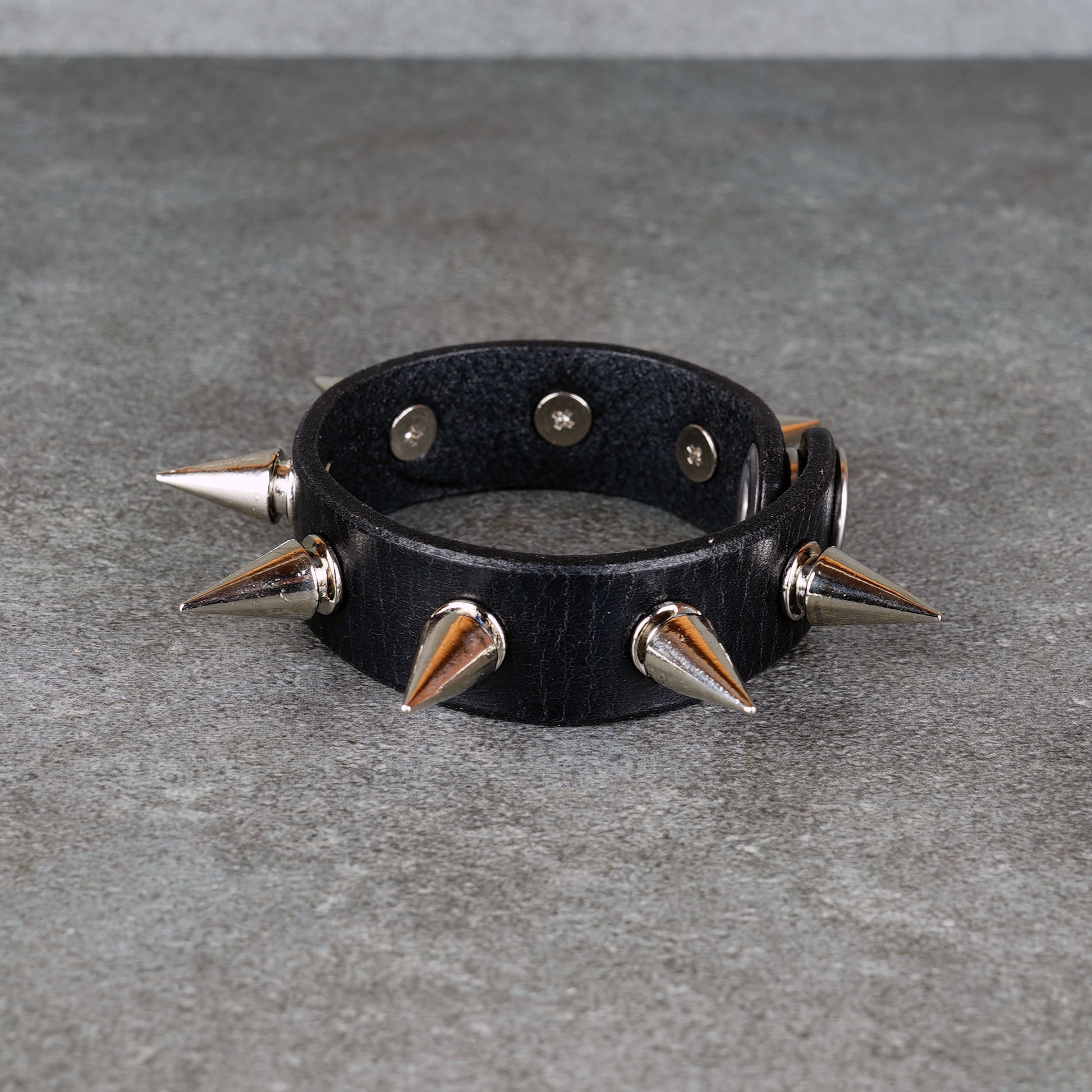 Black leather bracelet styled for punk rock outfits