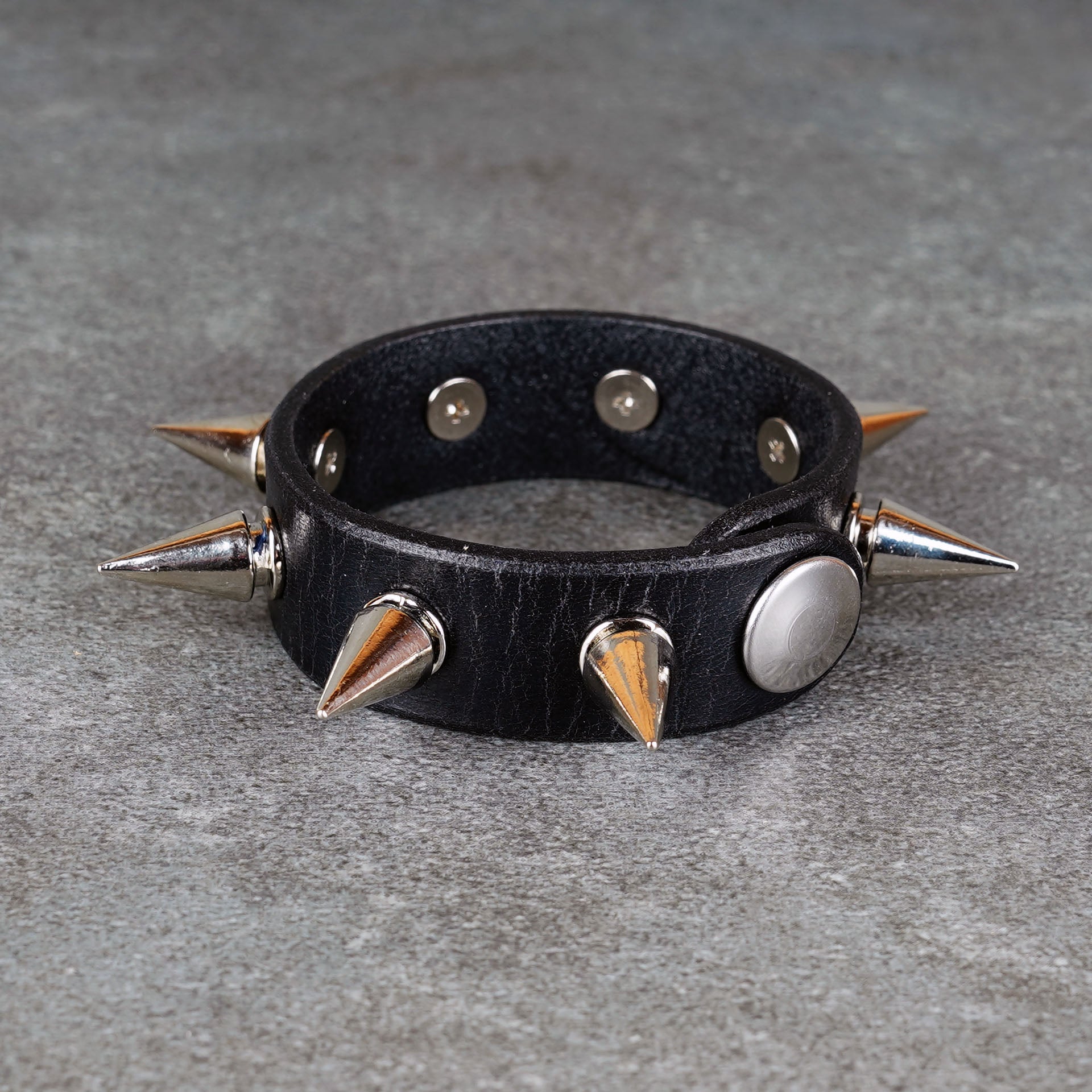 Black leather bracelet styled for punk rock outfits