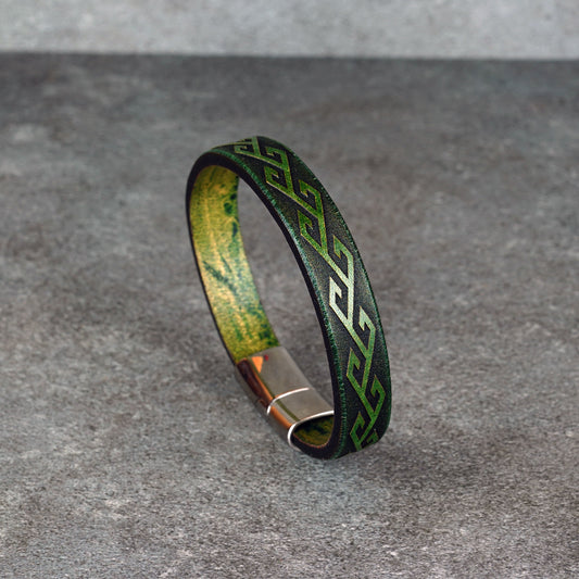 Angled view of the bracelet standing upright on a gray surface