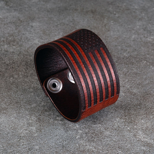 Close view of the bracelet laid open on a gray surface showing the engraved stripes