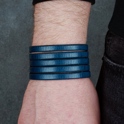 Blue leather wrap bracelet on gray background, handmade genuine leather cuff bracelet with layered strap design, minimalist blue wristband accessory for men and women
