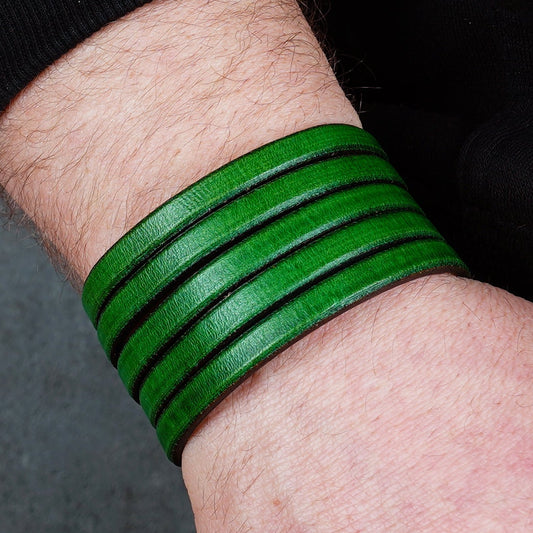 Green leather wrap bracelet on gray background, handmade genuine leather cuff bracelet with layered design, minimalist green wristband accessory for men and women
