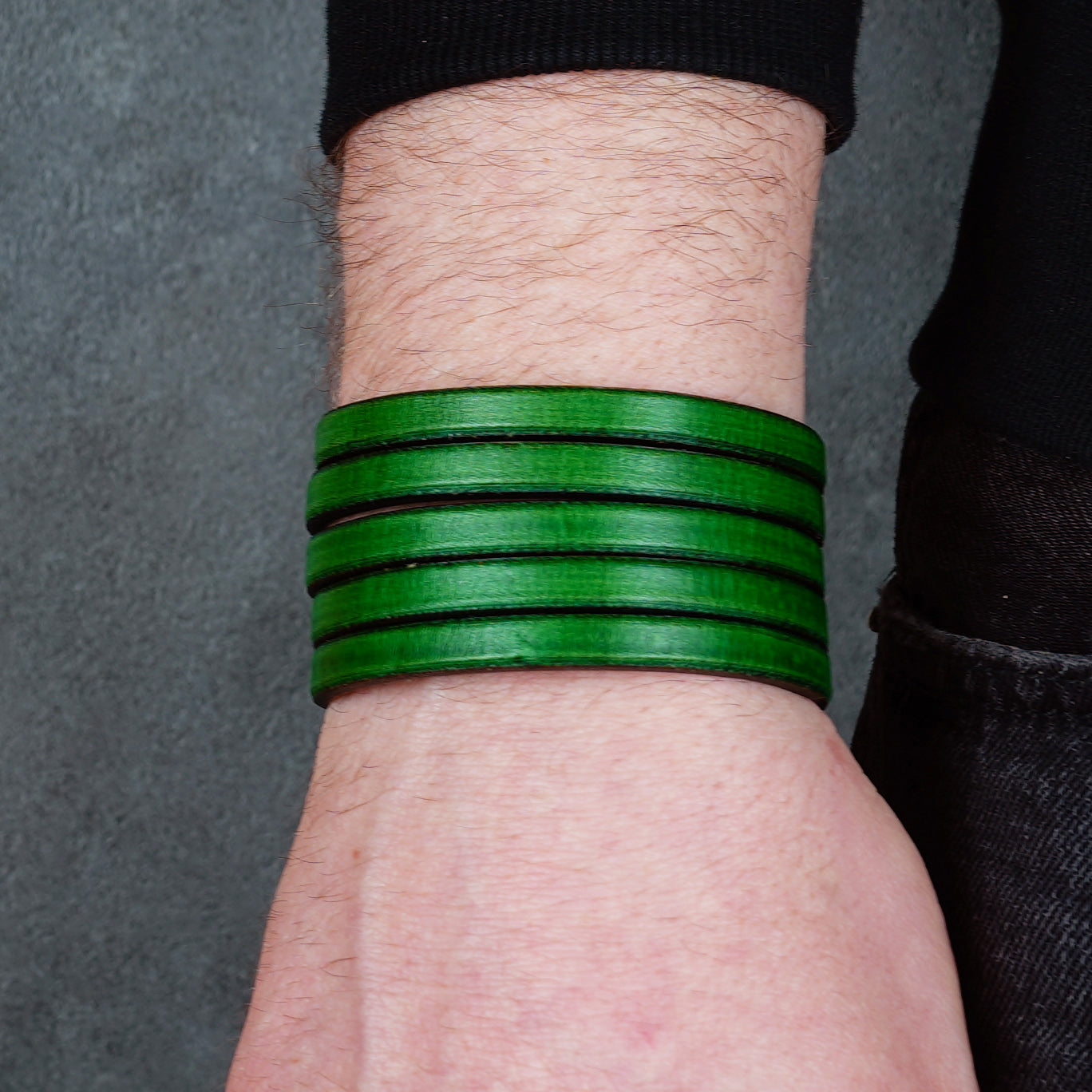 Green leather wrap bracelet on gray background, handmade genuine leather cuff bracelet with layered design, minimalist green wristband accessory for men and women
