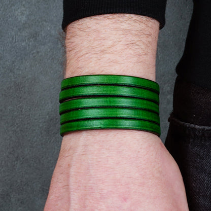 Green leather wrap bracelet on gray background, handmade genuine leather cuff bracelet with layered design, minimalist green wristband accessory for men and women
