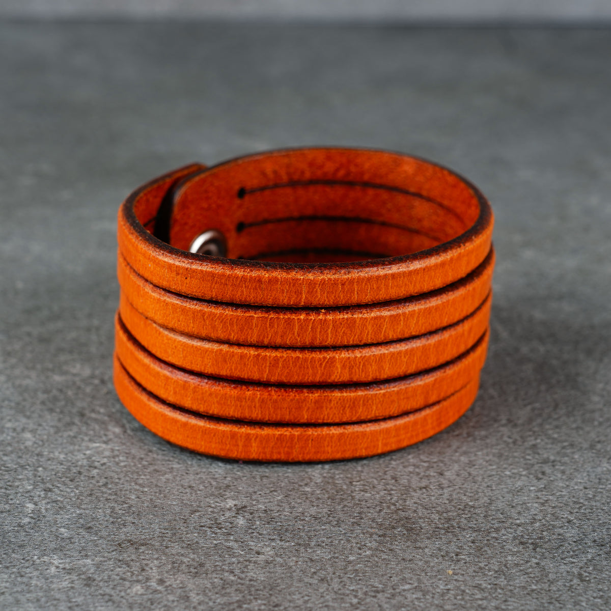 Close view of the bracelet opening and inner leather surface on a gray background
