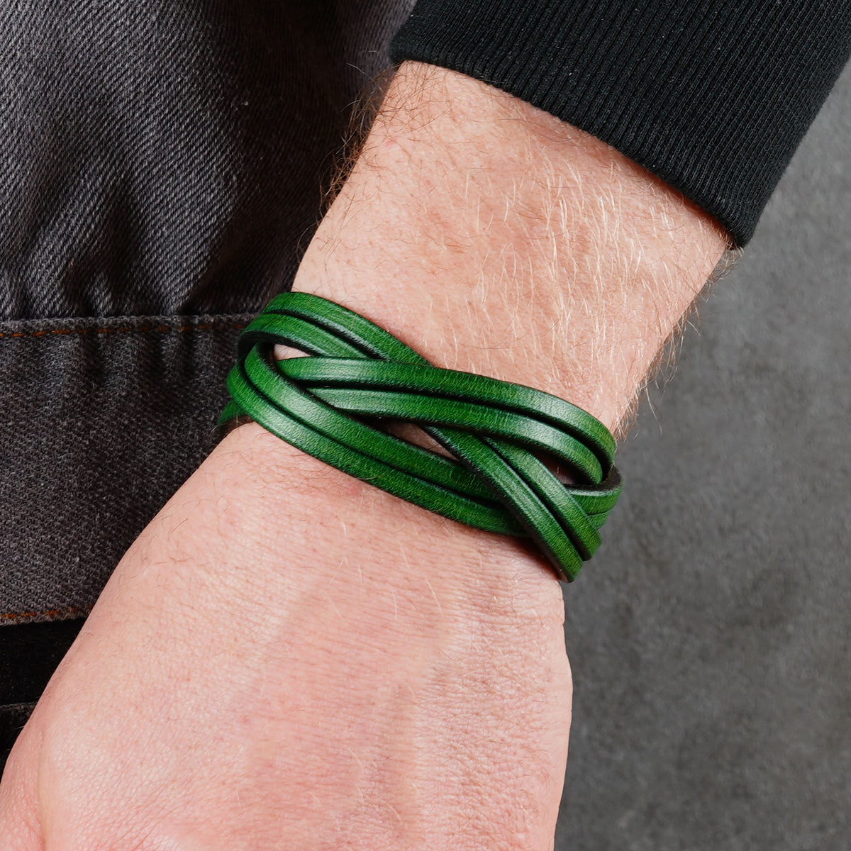 Green leather bracelet worn on a wrist from a closer side angle