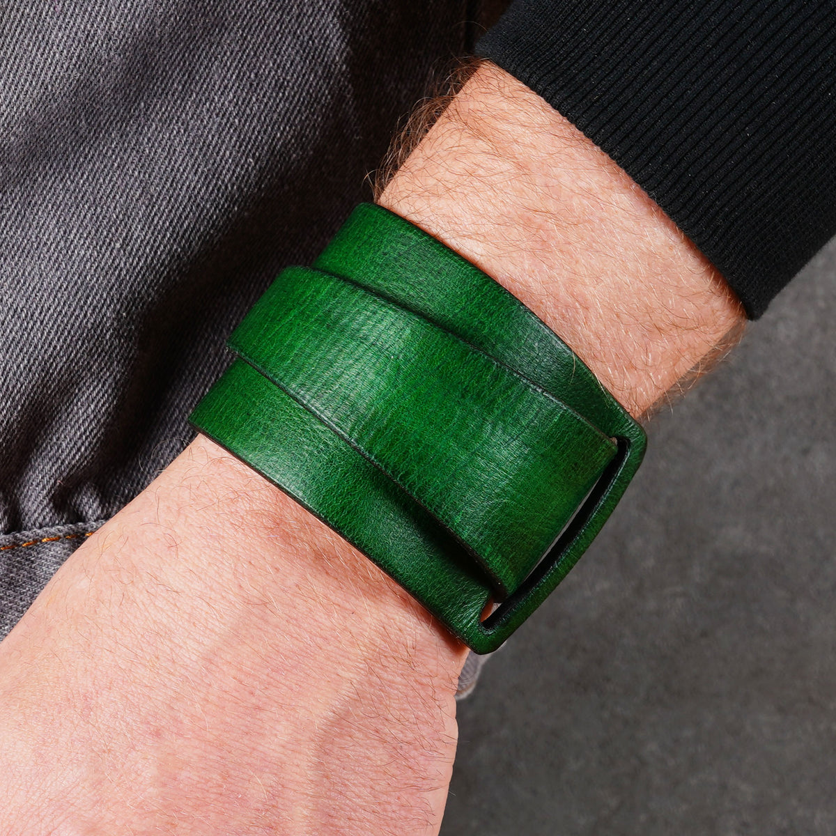 Green leather bracelet worn on a wrist with the cuff centered in frame