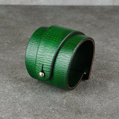 Green leather bracelet with a visible snap fastener shown against a gray background