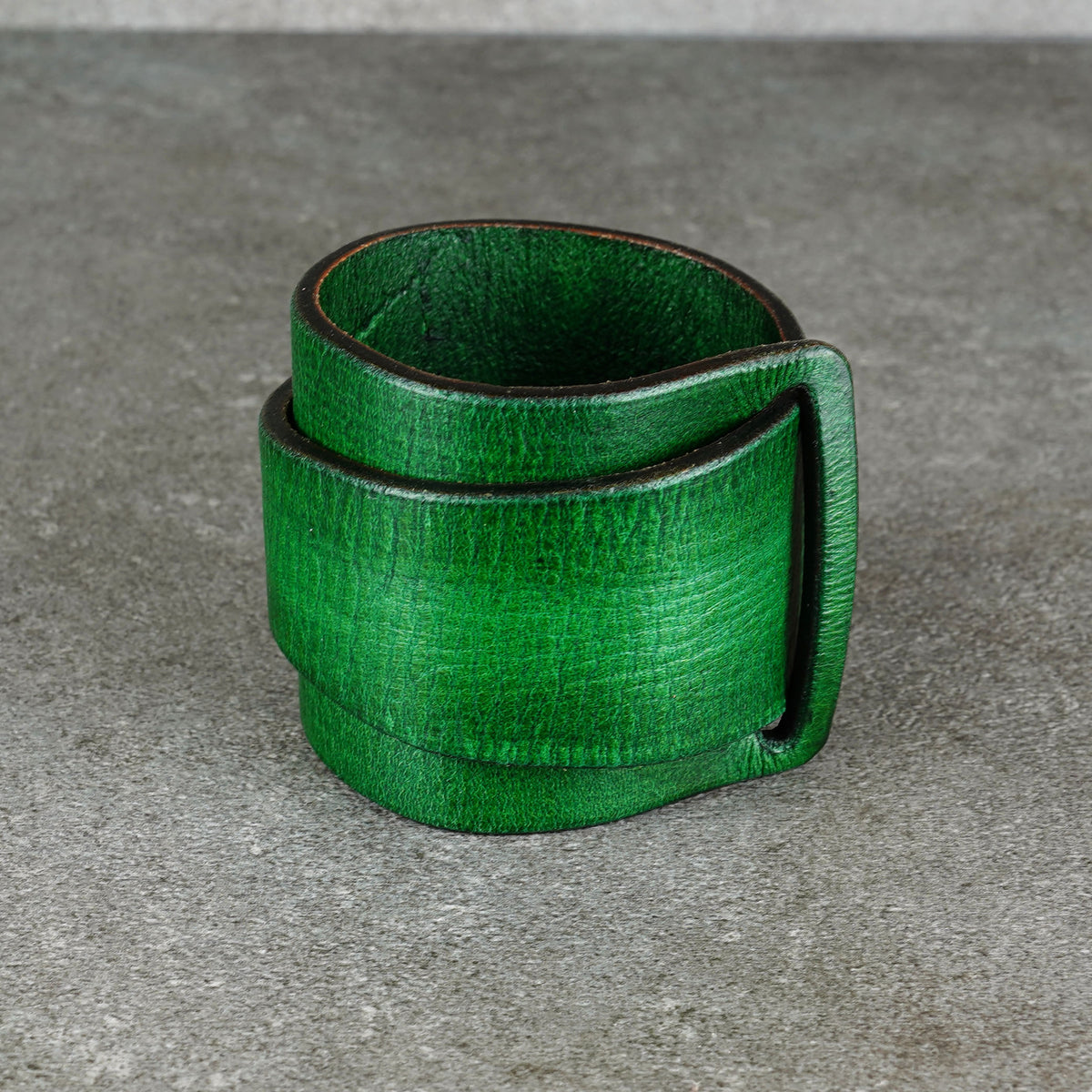 Green leather cuff bracelet with the snap detail visible from the side