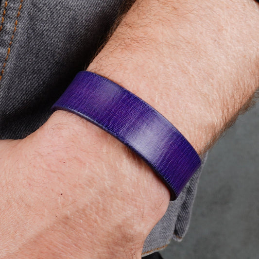 Purple leather cuff bracelet worn on a wrist with a side view