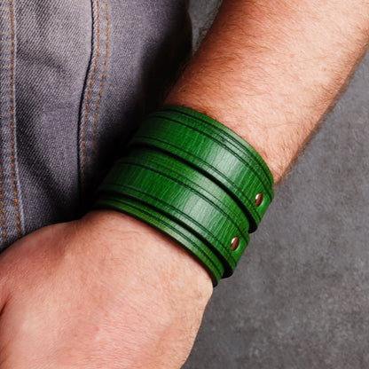 Close side view of a green leather cuff bracelet worn on a wrist