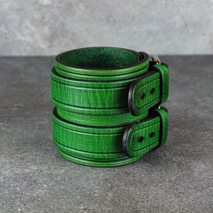 Studio view of the green cuff bracelet standing upright with the fastening side visible
