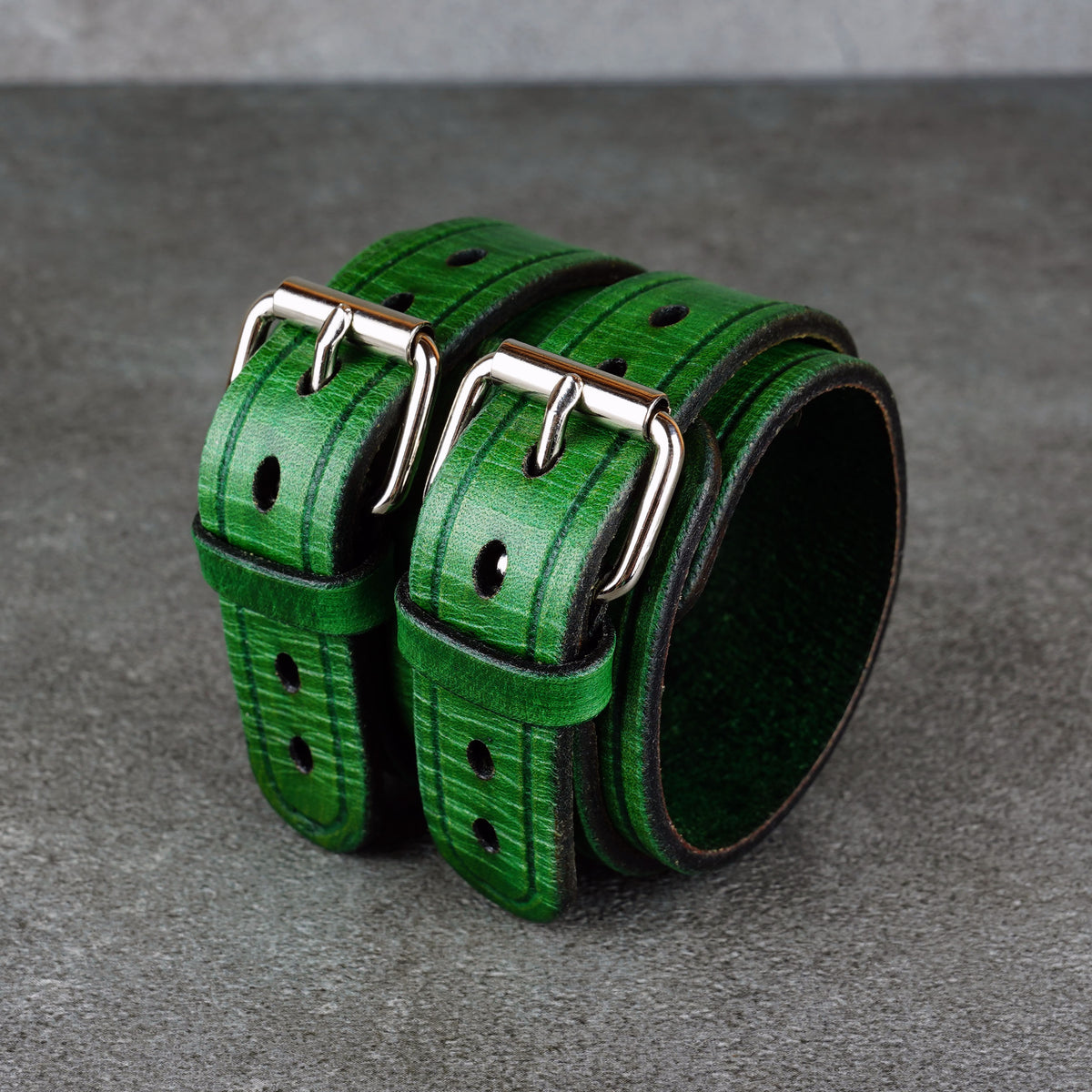 Single green cuff bracelet angled to show the curved opening and rivet detail